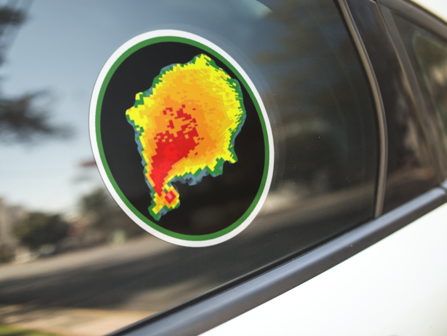 Radar reflectivity sticker with vibrant tornado hook echo design on a car window.