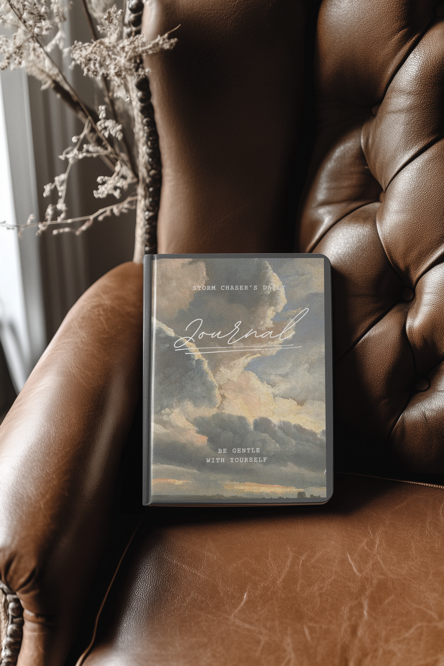 Storm Chaser's Daily Journal with a cloud cover design on a leather chair.