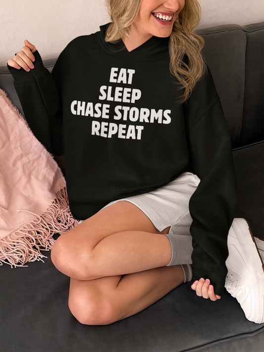 Hooded sweatshirt with "Eat Sleep Chase Storms Repeat" quote, ideal for storm chasers and weather enthusiasts.